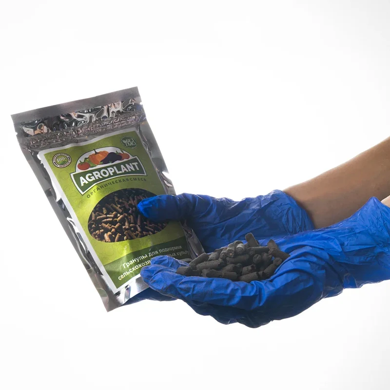 Упаковка гранулированного удобрения Агроплант и гранулы в руке с надетой синей перчаткой