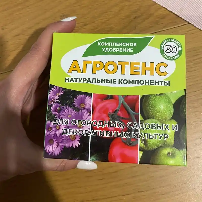 Рука держит упаковку удобрения Агротенс