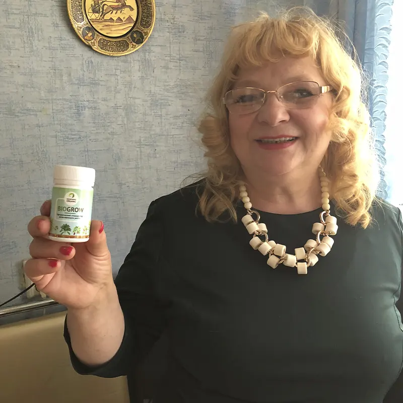 Улабающаяся женщина в очках хвастается покупкой удобрения BioGrow