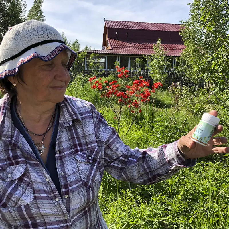 Женщина садовод изучает способ применения удобрения BioGrow написанный на баночке