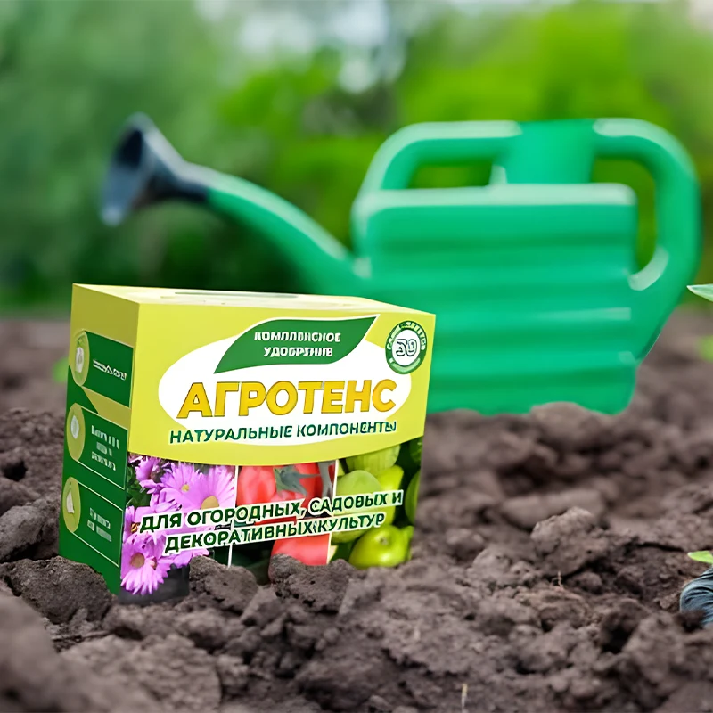 Агротенс в земляной грядке рядом с зелёной лейкой