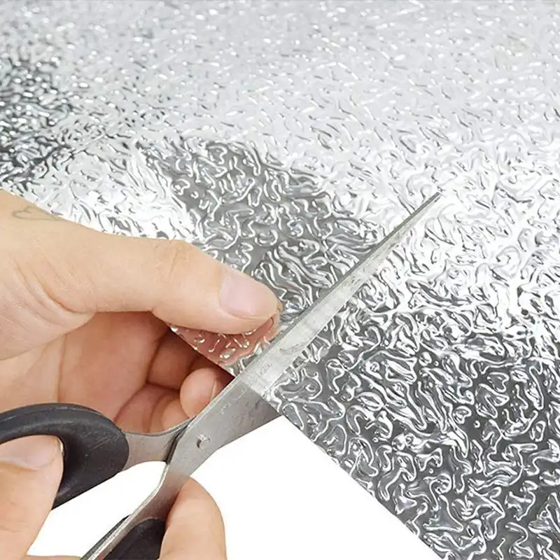 Ножницы режут фольгу-стикер