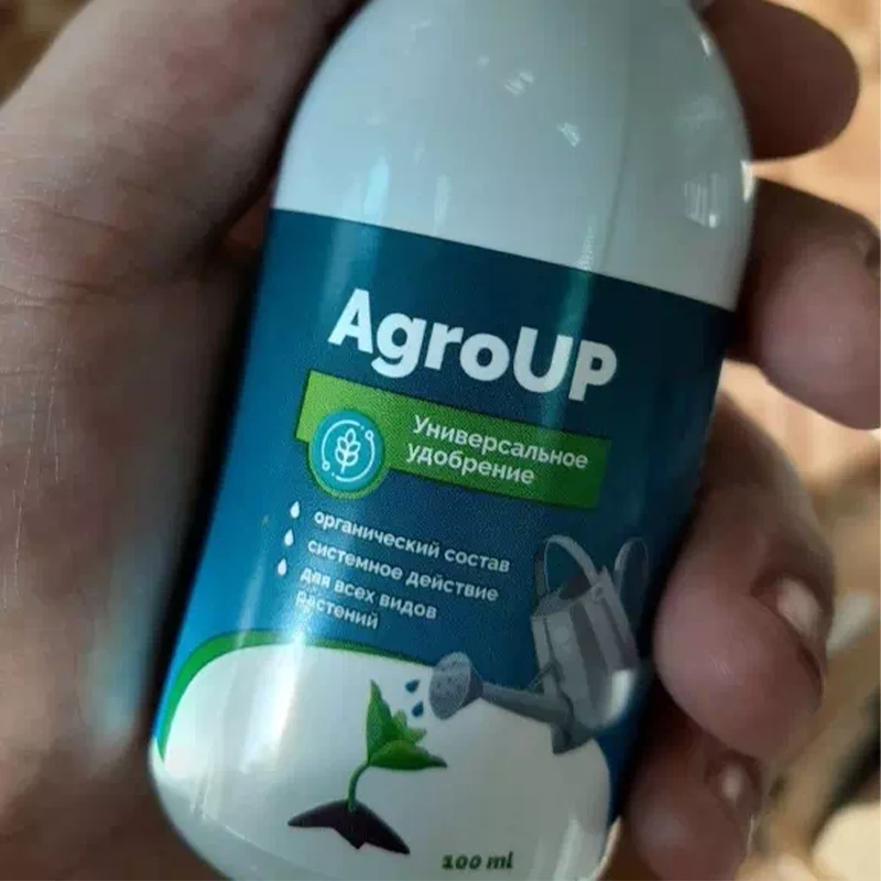 Рука держит бутылочку AgroUP близкий ракурс