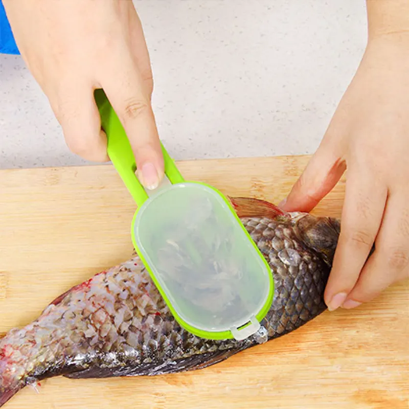 Рука чистит зелёной рыбочисткой Cleanfish карпа