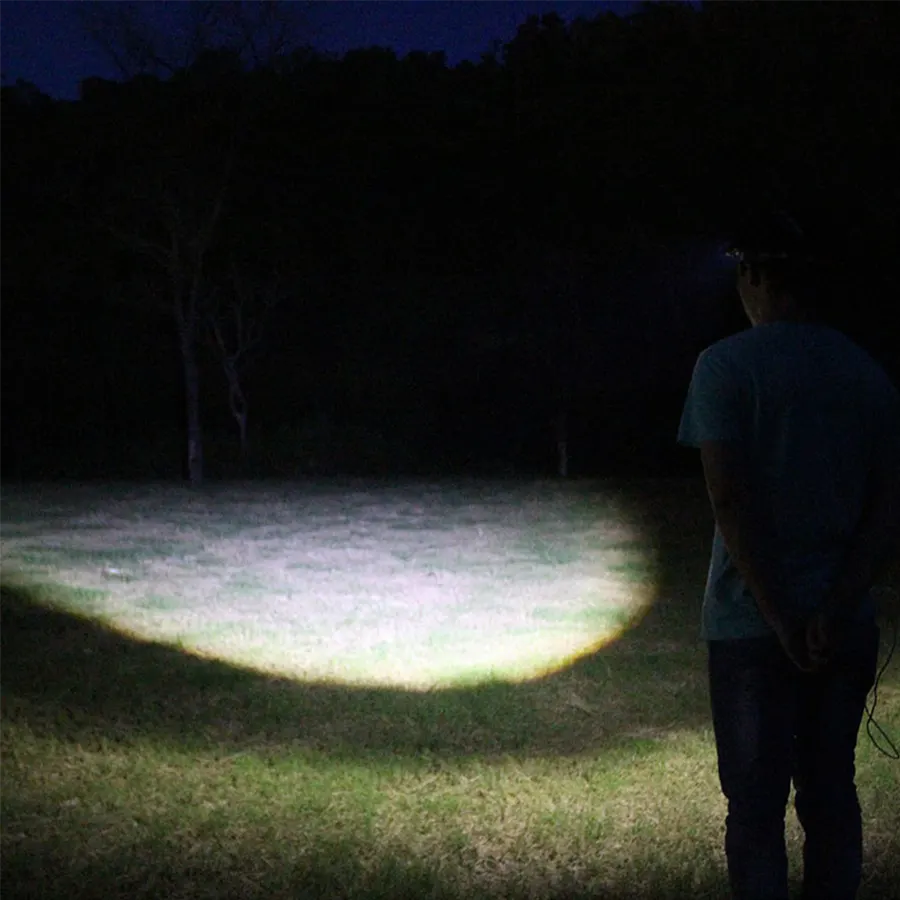 Луч света от налобного фонаря ночью в лесу