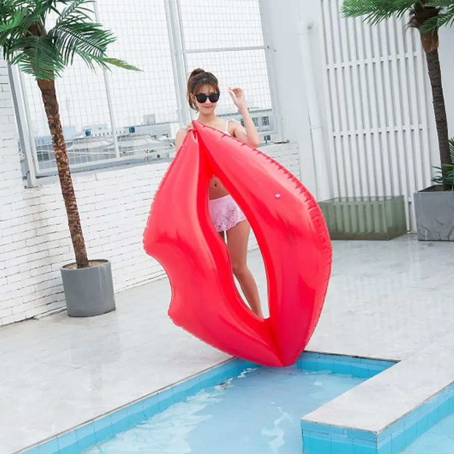 Девушка в солнцезащитных очках дрежит красные губы для плавания