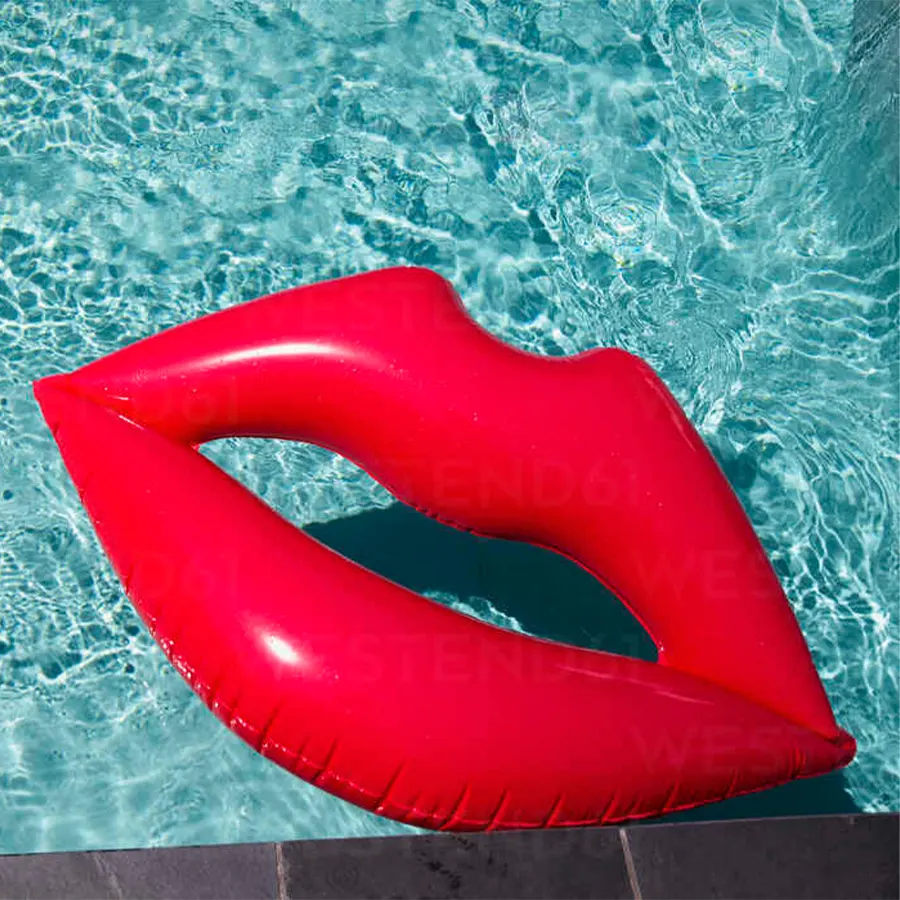 Надувные красные губы плавают в бассейне
