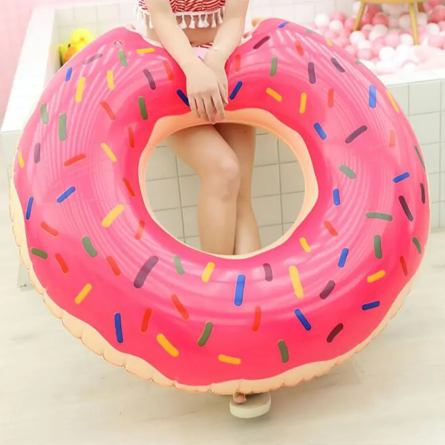 Девушка держит надувной пончик для купания