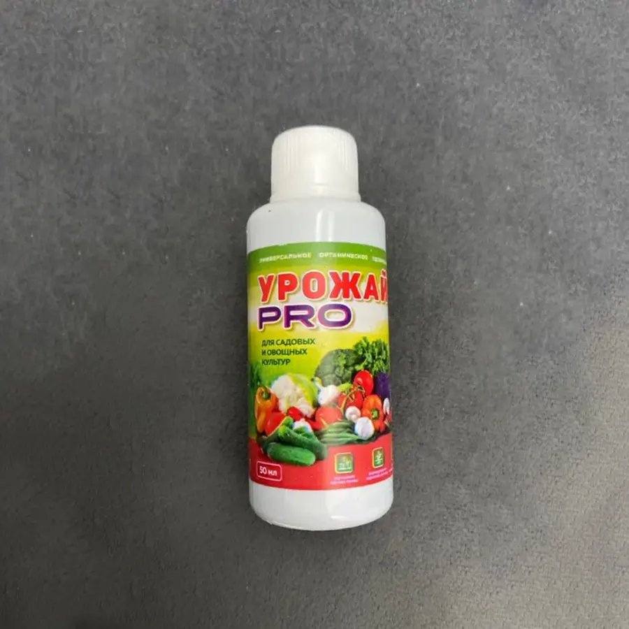 Бутылочка с Урожай PRO лежит на сером ковре