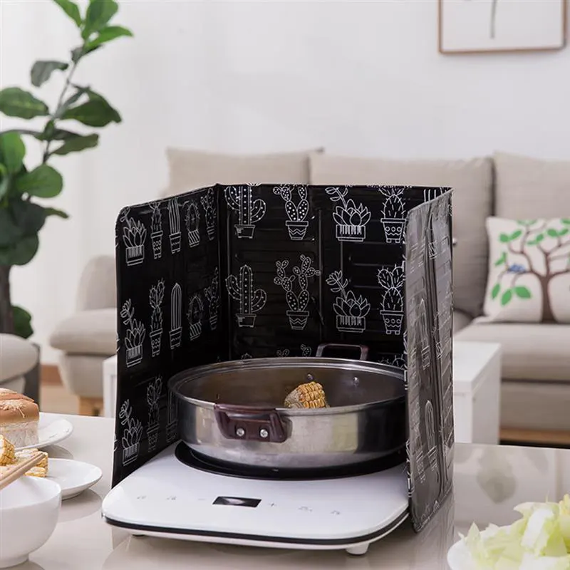 Чёрная хаслонка стоит на столе в гостинной и защищает всё вокруг от жира и брызг