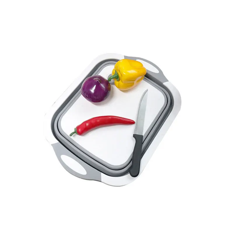 Перцы и нож лежат на складной разделочной доске