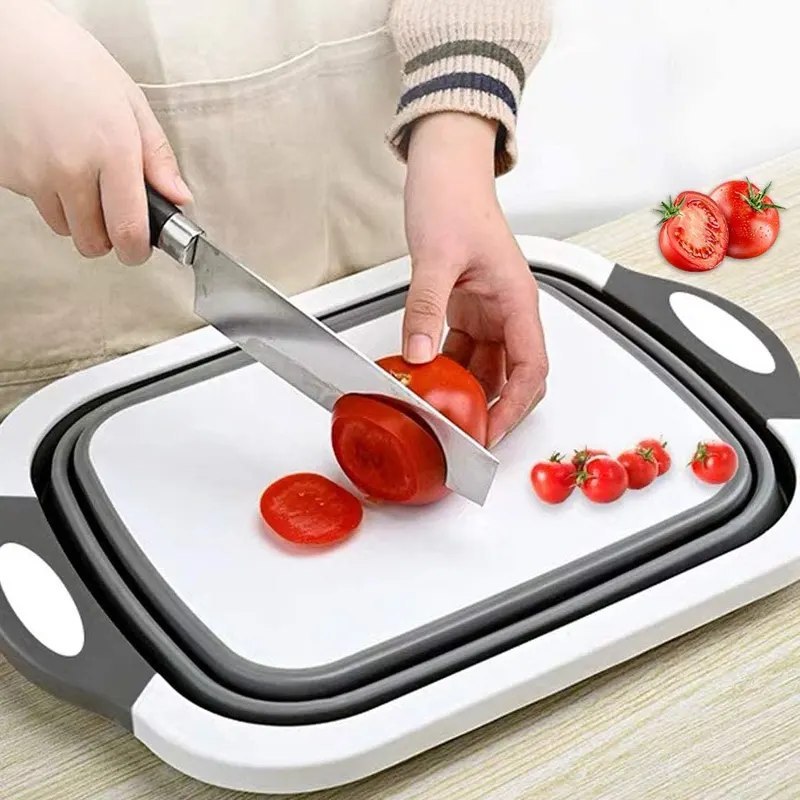 Руки режут помидор на складной разделочной доске