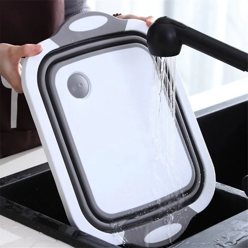 Складную разделочную доску моют под краном