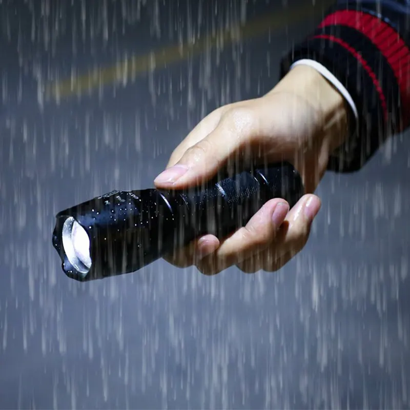 Фонарик Атомный луч держат в руке под дождём