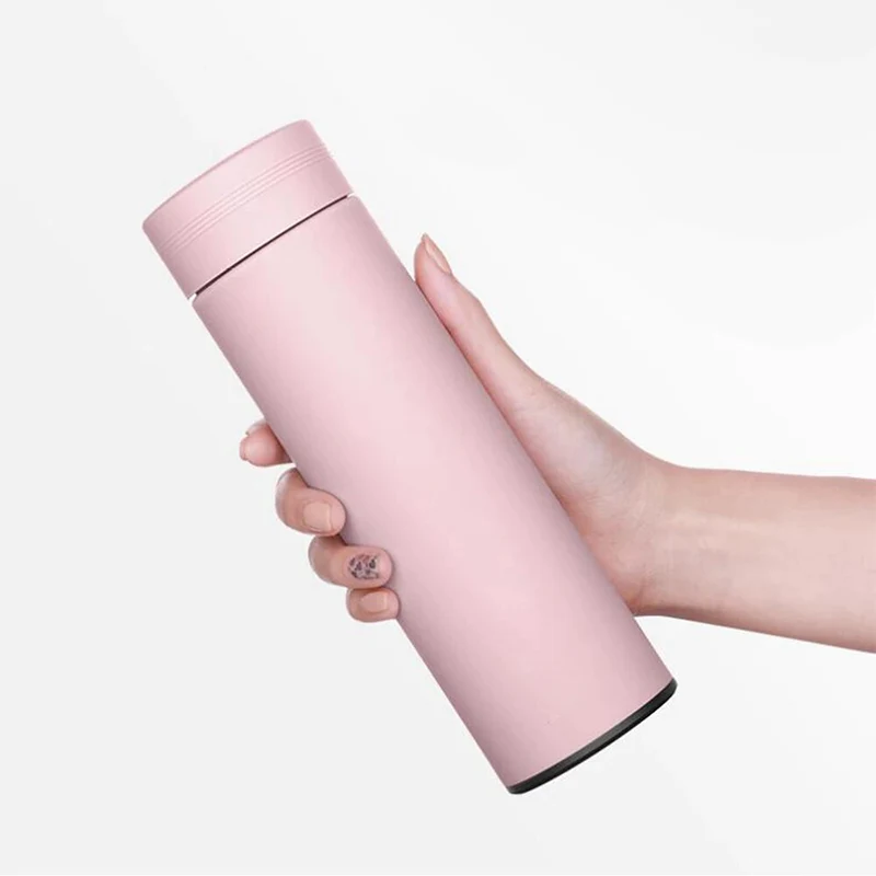 Рука держит розовый термос