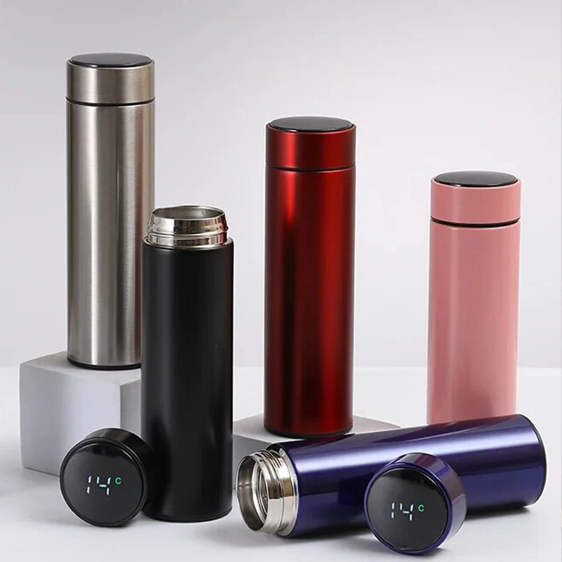 Металический, чёрный, красный, розовый, синий термосы с датчиками температуры стоят на белом фоне