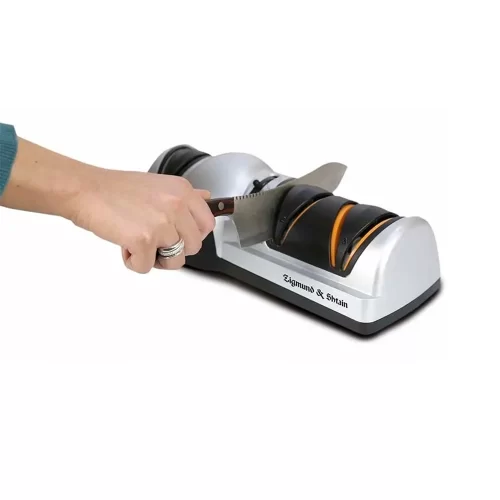 Рука точит шеф нож в электрической ножеточке Zigmund