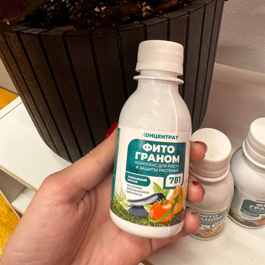 Женская рука держит бутылочка с концентратом Фитограном